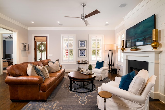 living room featuring baseboards, a fireplace, dark wood finished floors, and crown molding