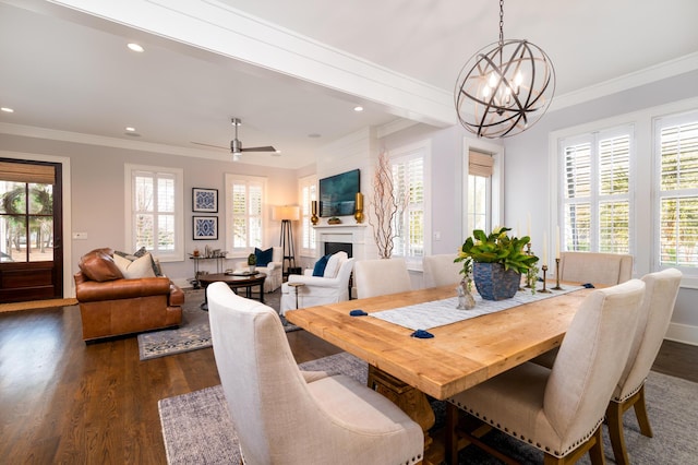 dining space featuring dark wood-style flooring, a fireplace, recessed lighting, ornamental molding, and ceiling fan with notable chandelier