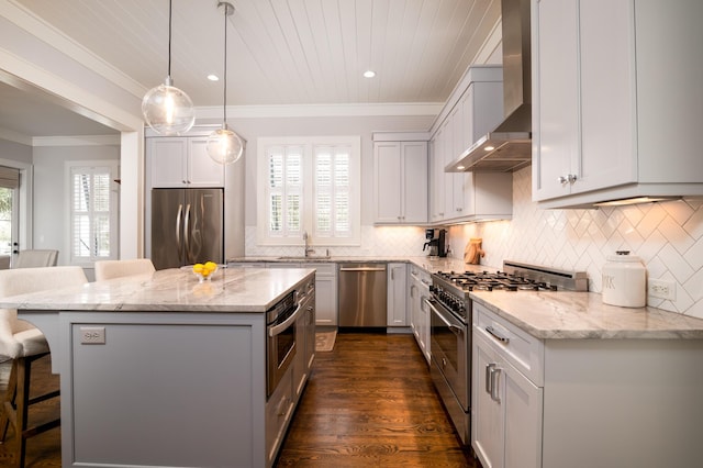 kitchen featuring wall chimney exhaust hood, appliances with stainless steel finishes, a breakfast bar area, and light stone countertops