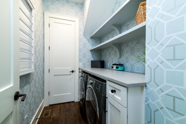 washroom with laundry area, separate washer and dryer, dark wood-style flooring, visible vents, and wallpapered walls