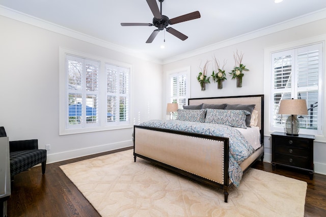 bedroom featuring baseboards, multiple windows, ornamental molding, and wood finished floors