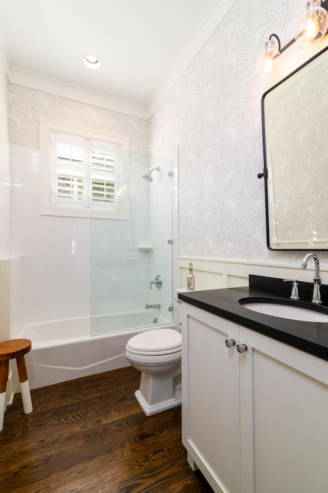 full bathroom featuring wood finished floors, a wainscoted wall, crown molding, and wallpapered walls