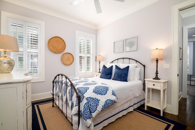 bedroom featuring dark wood finished floors, crown molding, baseboards, and ceiling fan