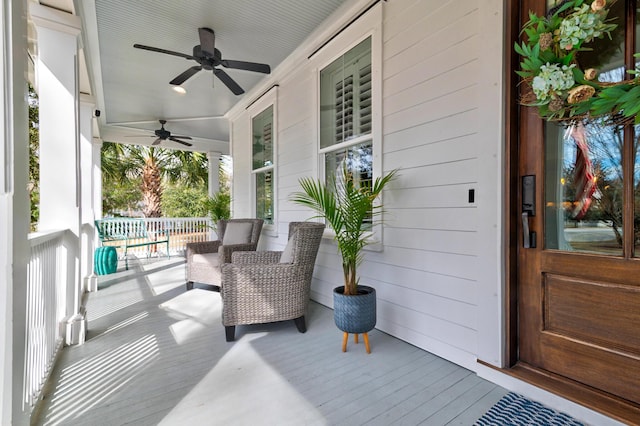 wooden deck with a porch and a ceiling fan