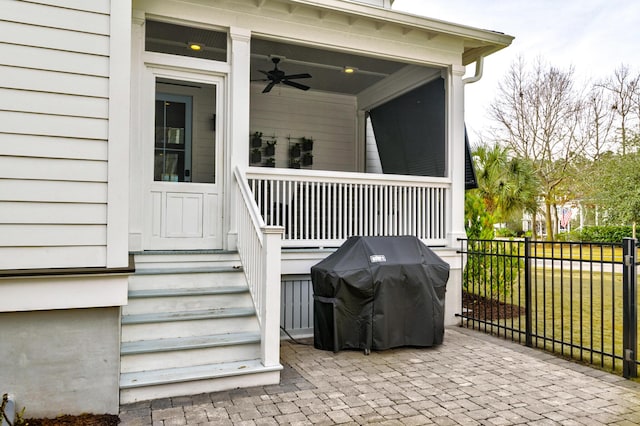 doorway to property with fence and a ceiling fan