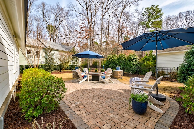 view of patio with an outdoor fire pit and fence