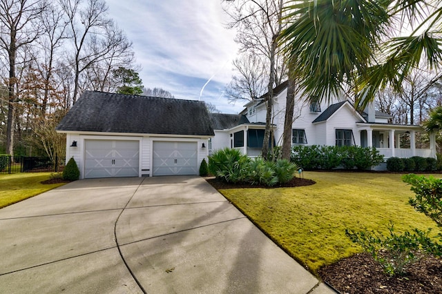 view of front of home with a garage, a shingled roof, and a front lawn