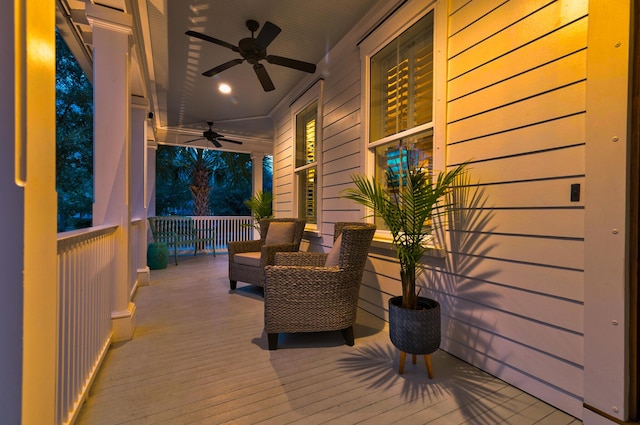 wooden terrace featuring covered porch and a ceiling fan