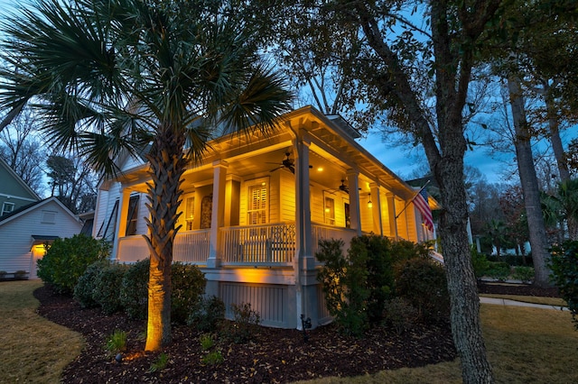 property exterior at dusk featuring covered porch and a ceiling fan