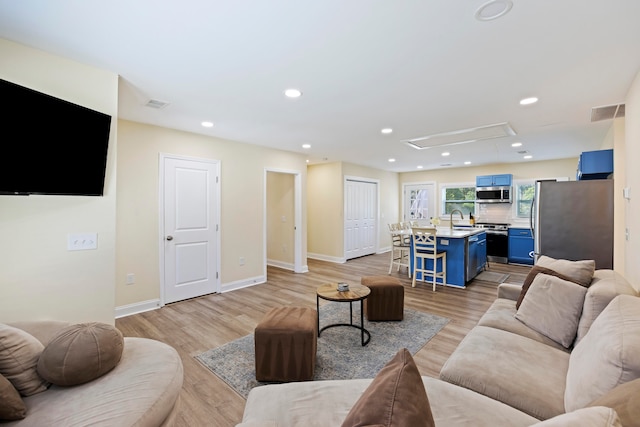 living room with light wood-type flooring and sink