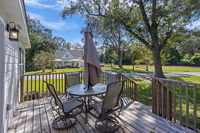 wooden deck featuring a lawn