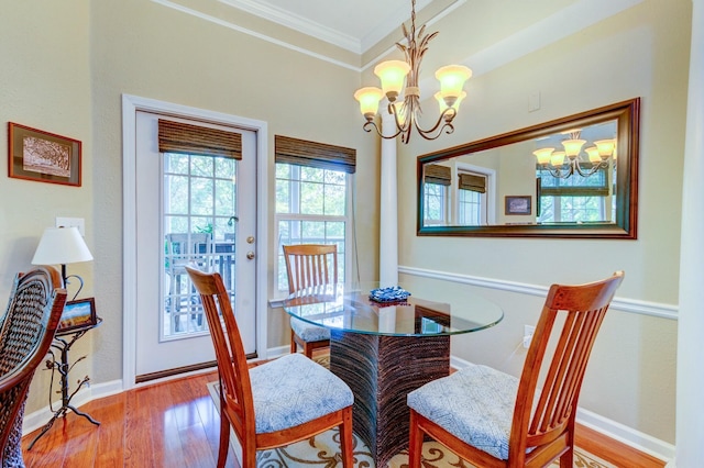 dining room featuring baseboards, wood finished floors, a chandelier, and crown molding