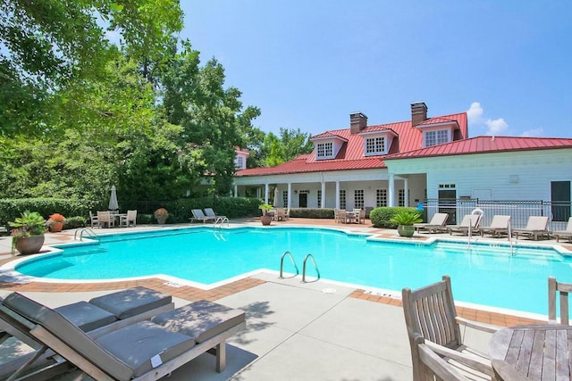 community pool featuring a patio area and fence