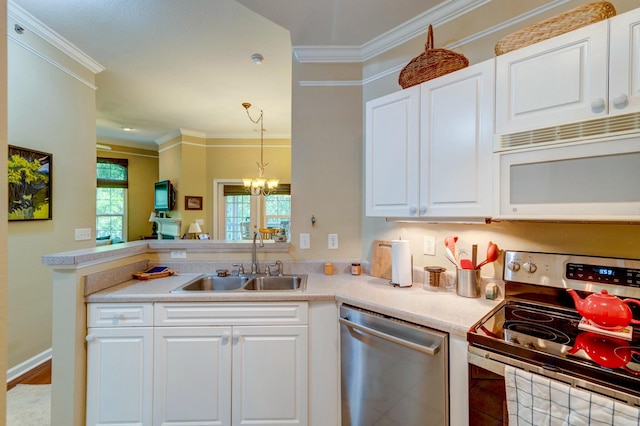 kitchen with crown molding, a sink, appliances with stainless steel finishes, white cabinets, and a notable chandelier