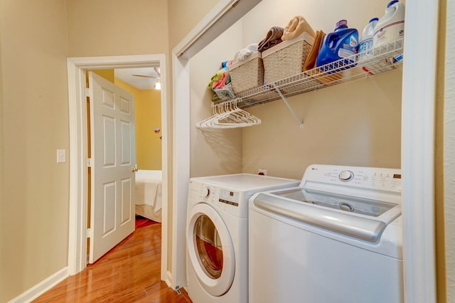 laundry area featuring light wood-style flooring, washing machine and clothes dryer, baseboards, and laundry area