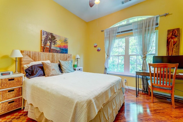 bedroom featuring wood finished floors, visible vents, and baseboards