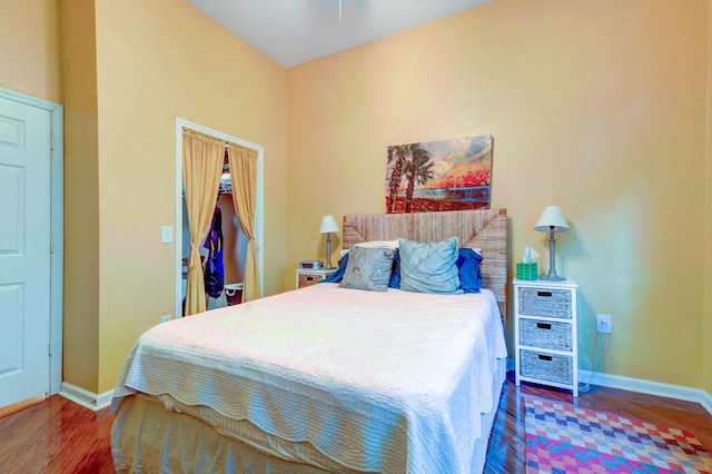 bedroom with baseboards, wood finished floors, and a closet