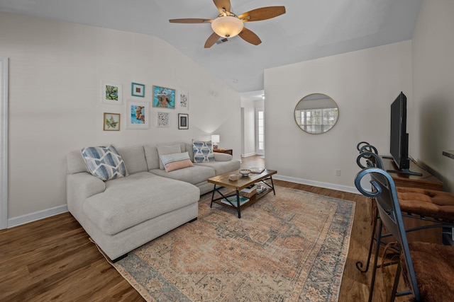 living area featuring a ceiling fan, lofted ceiling, baseboards, and wood finished floors