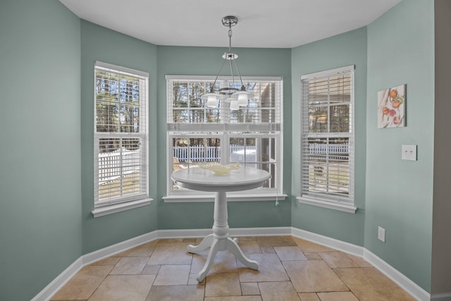 dining area featuring a notable chandelier and baseboards