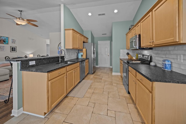 kitchen with visible vents, lofted ceiling, stainless steel appliances, light brown cabinetry, and a sink