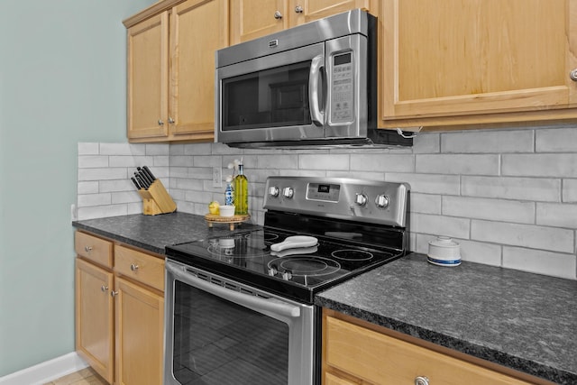 kitchen with baseboards, stainless steel appliances, backsplash, and light brown cabinetry