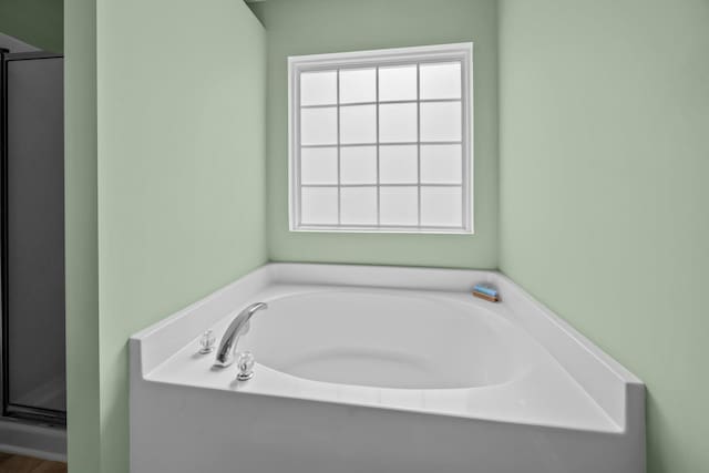 full bath featuring a garden tub and a shower stall