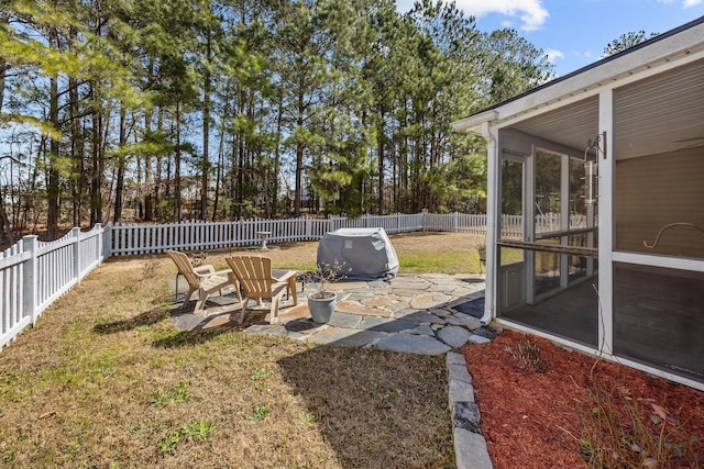 view of yard featuring a sunroom, a fenced backyard, and a patio area