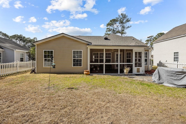 back of property with a yard, roof with shingles, fence, and a sunroom