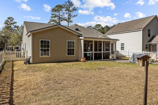 rear view of property with a yard, roof with shingles, a fenced backyard, and a sunroom