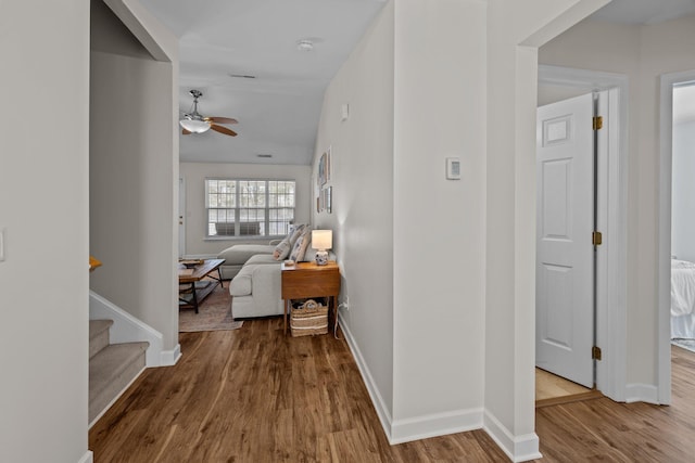 hallway with baseboards and wood finished floors