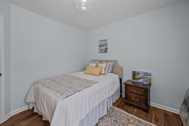 bedroom with baseboards and wood finished floors