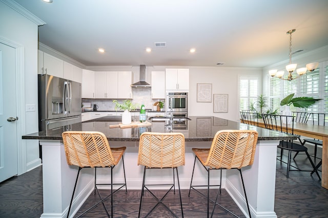 kitchen featuring a center island with sink, white cabinetry, wall chimney exhaust hood, and stainless steel fridge with ice dispenser