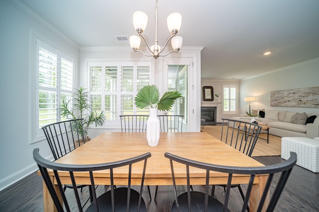 dining space featuring crown molding, a healthy amount of sunlight, an inviting chandelier, and dark hardwood / wood-style floors