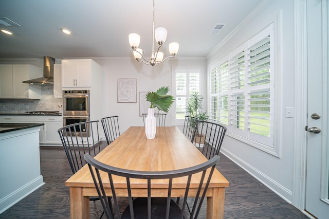 dining area featuring crown molding, an inviting chandelier, and dark hardwood / wood-style floors