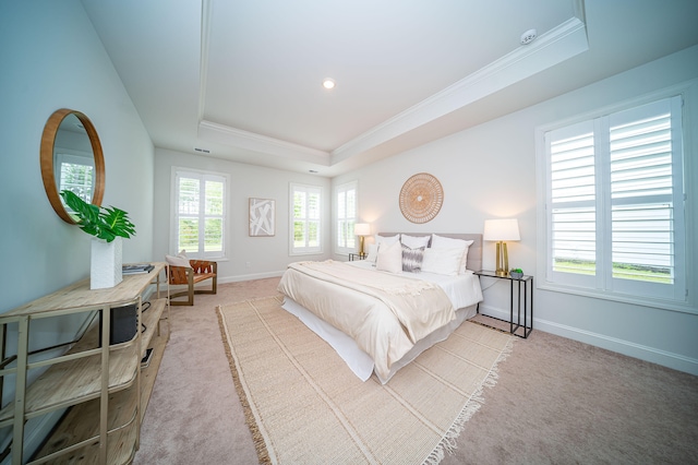 carpeted bedroom featuring multiple windows, a tray ceiling, and ornamental molding