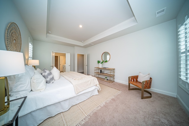 carpeted bedroom with ornamental molding and a raised ceiling