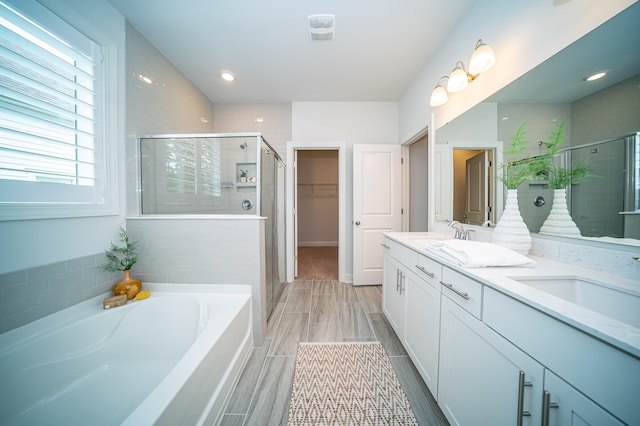 bathroom with vanity, hardwood / wood-style floors, and plus walk in shower