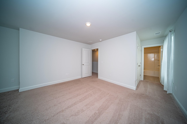 interior space featuring light carpet and ensuite bathroom