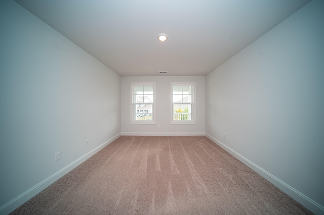 spare room featuring light colored carpet