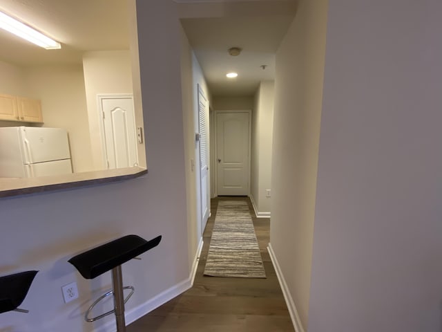 hallway with dark hardwood / wood-style flooring