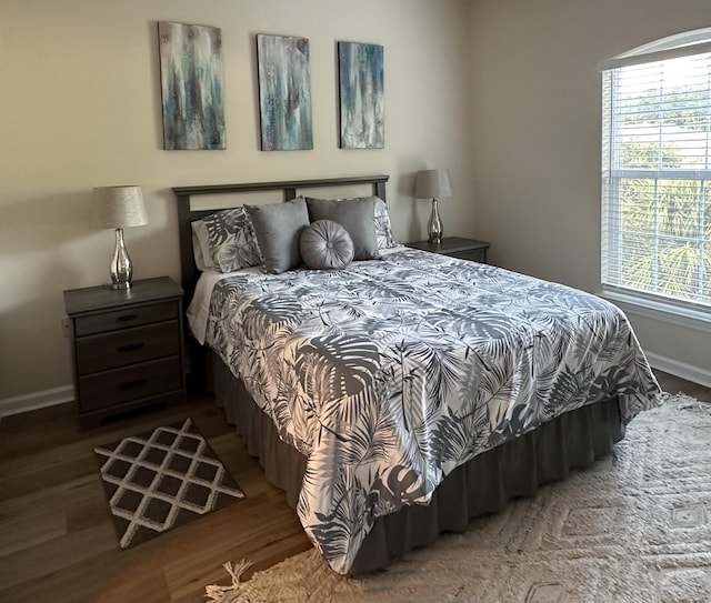 bedroom with dark hardwood / wood-style flooring