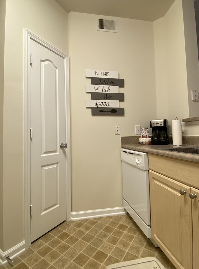 kitchen with sink, light brown cabinetry, and white dishwasher