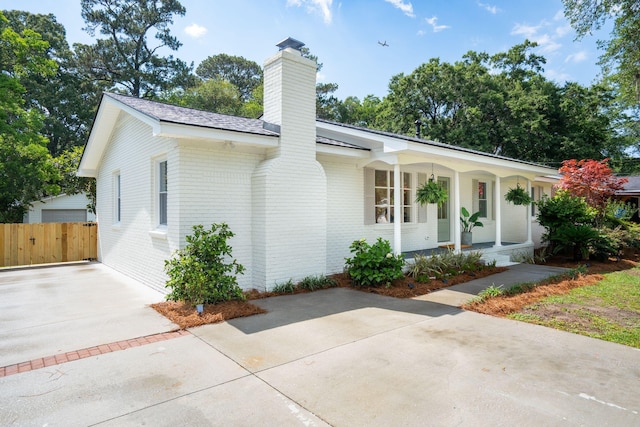 521 Carpenter St, Charleston, SC 29412 - view of front facade with a chimney, a porch, brick siding, and fence