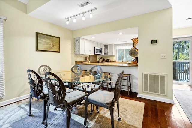 dining room with sink, dark wood-type flooring, and a wealth of natural light