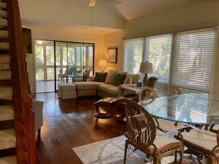 living room featuring lofted ceiling, dark hardwood / wood-style flooring, and ceiling fan