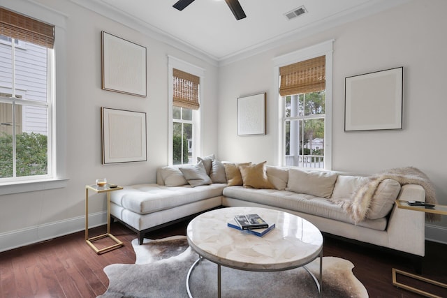 living room with dark wood-style floors, ornamental molding, plenty of natural light, and visible vents