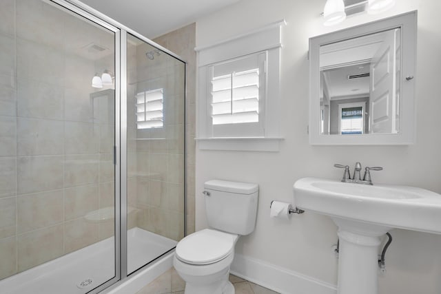 full bath featuring toilet, a stall shower, a sink, tile patterned flooring, and baseboards