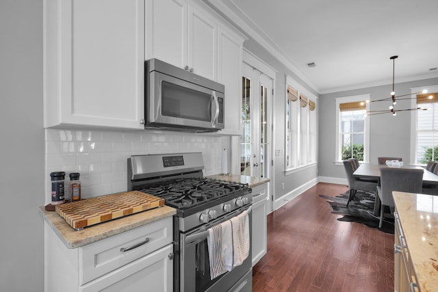 kitchen with stainless steel appliances, dark wood-style flooring, white cabinetry, ornamental molding, and backsplash