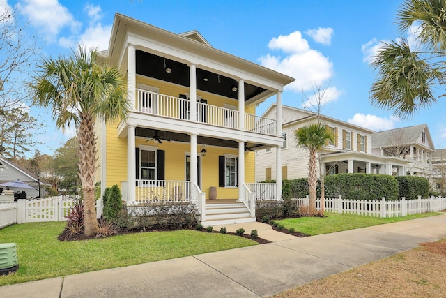 view of front facade featuring a porch, a front yard, fence, and a balcony