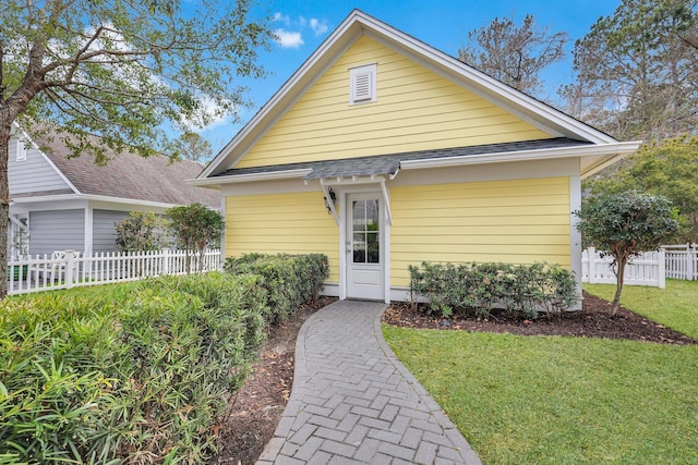 bungalow-style house with a front yard and fence